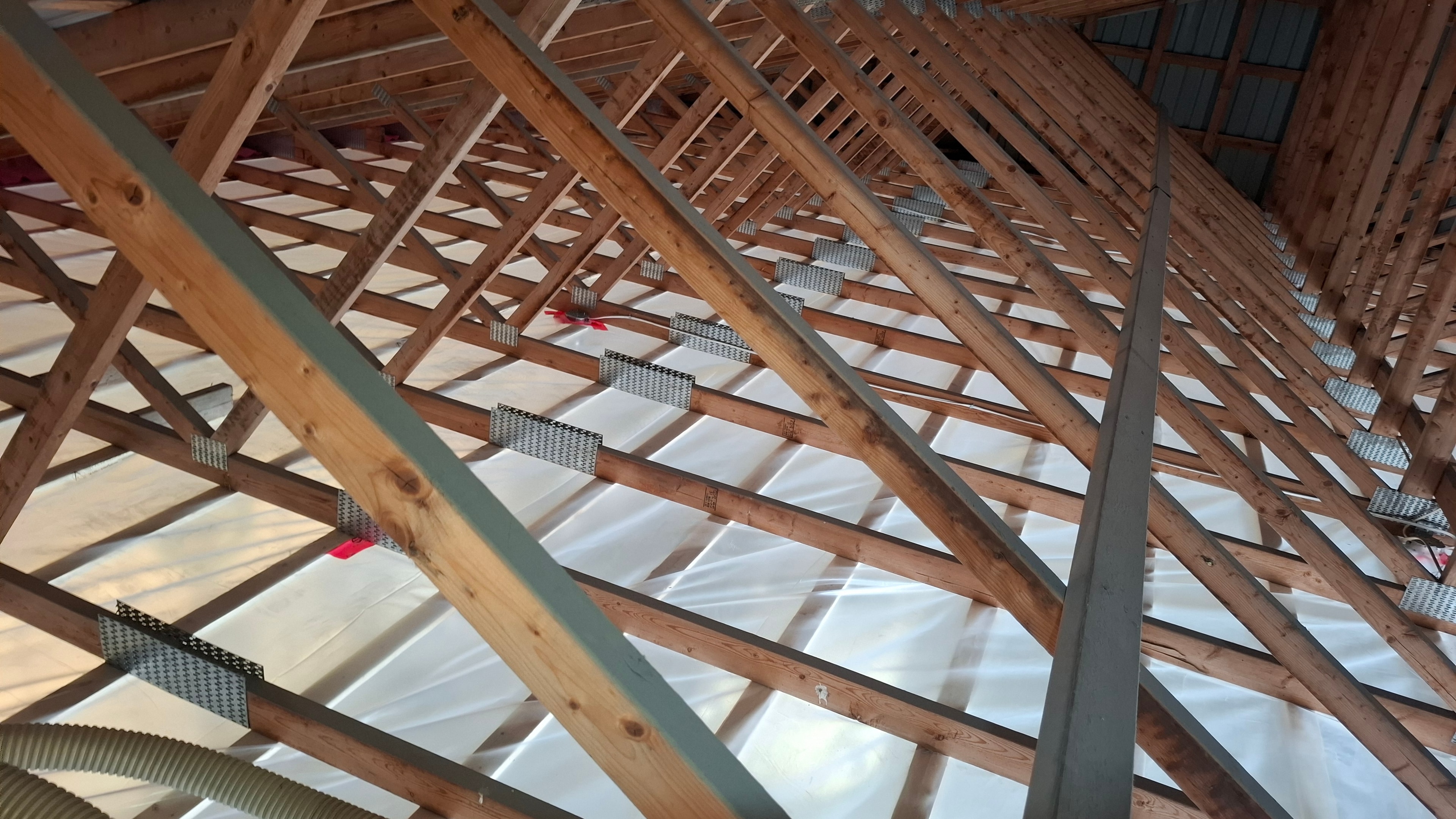 New construction attic framing with vapour barrier and ventilation baffles installed