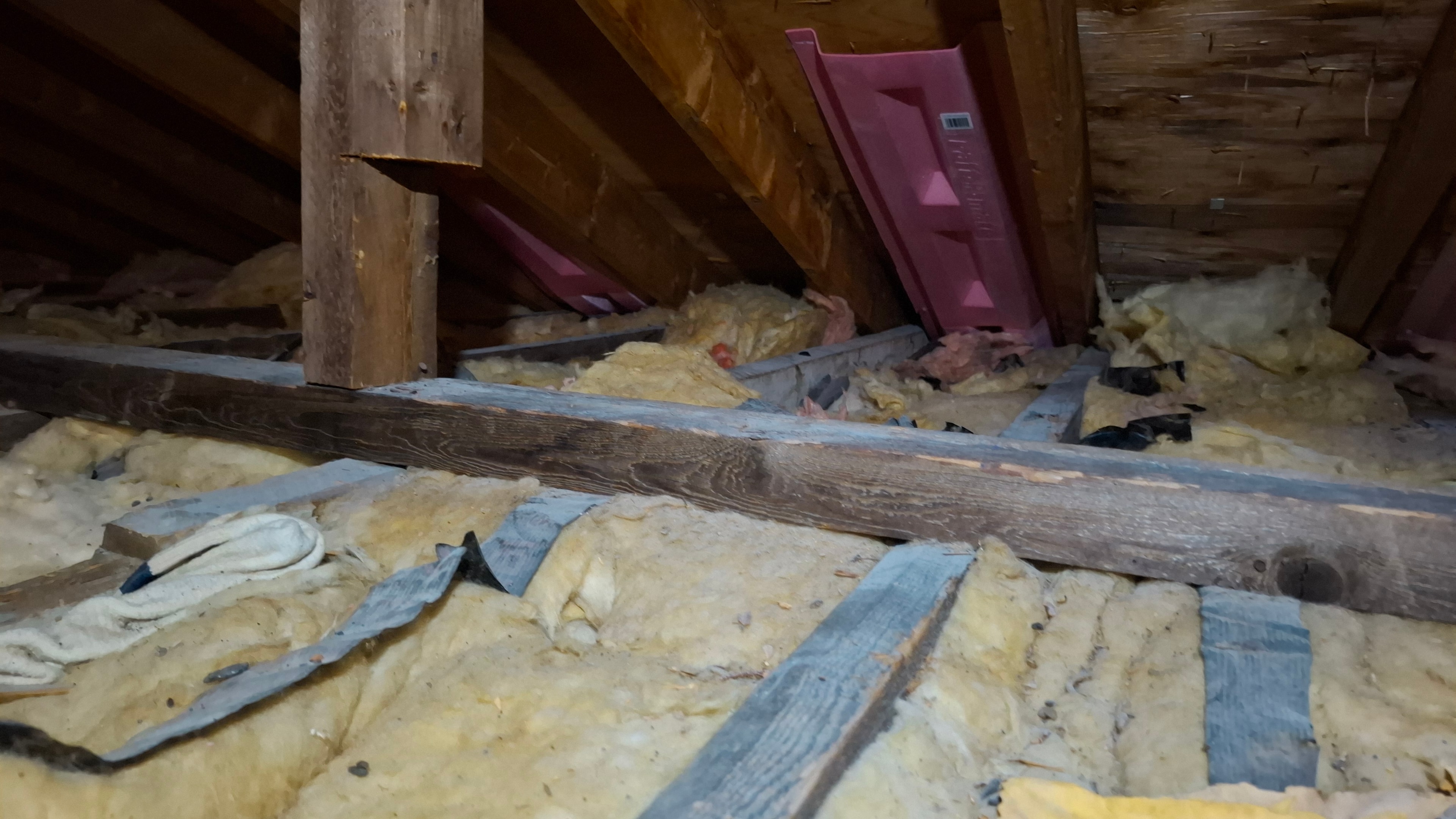 Attic before — existing insulation with ventilation baffles visible at eaves