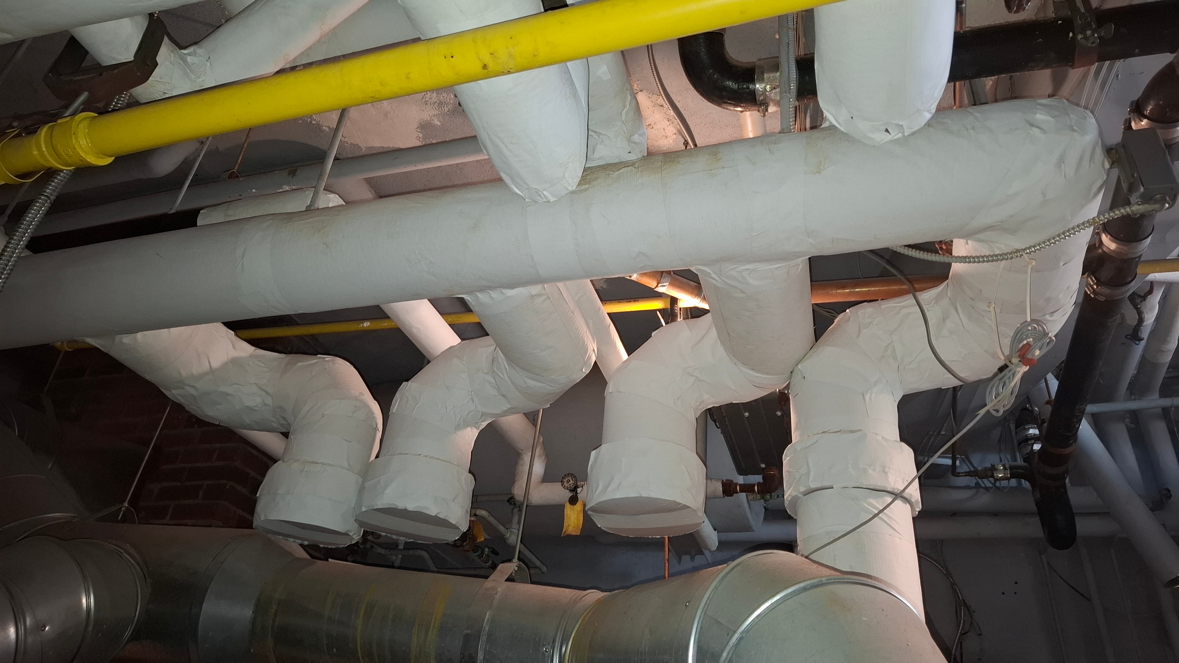Overhead view of fiberglass pipe insulation with ASJ jacketing on heating lines
