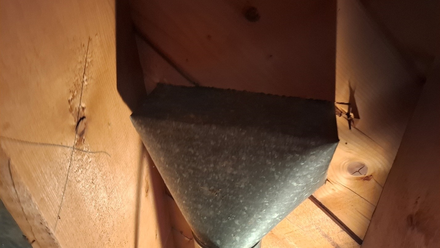Clean galvanized duct boot between wood framing after ACM paper removal