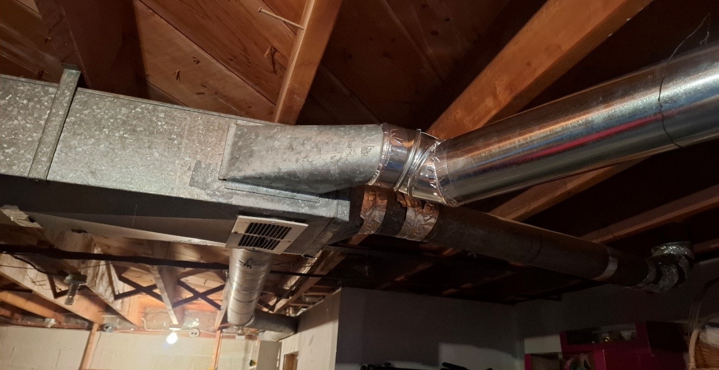 Main trunk duct with ACM paper visible alongside new branch duct — during abatement
