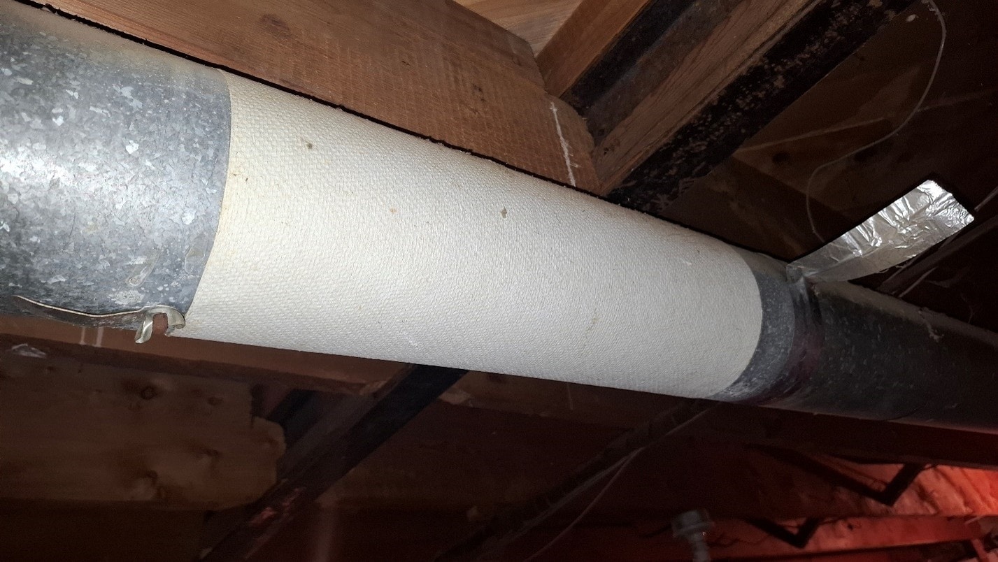 New duct wrap installed on round HVAC duct after ACM paper removal — after