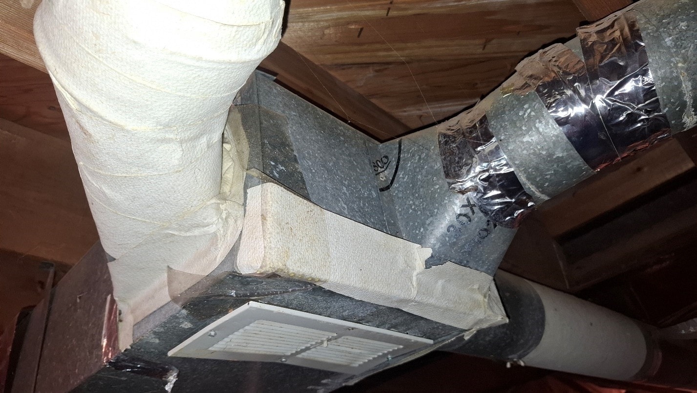 ACM paper on HVAC duct junction with register boot and flex duct — before removal