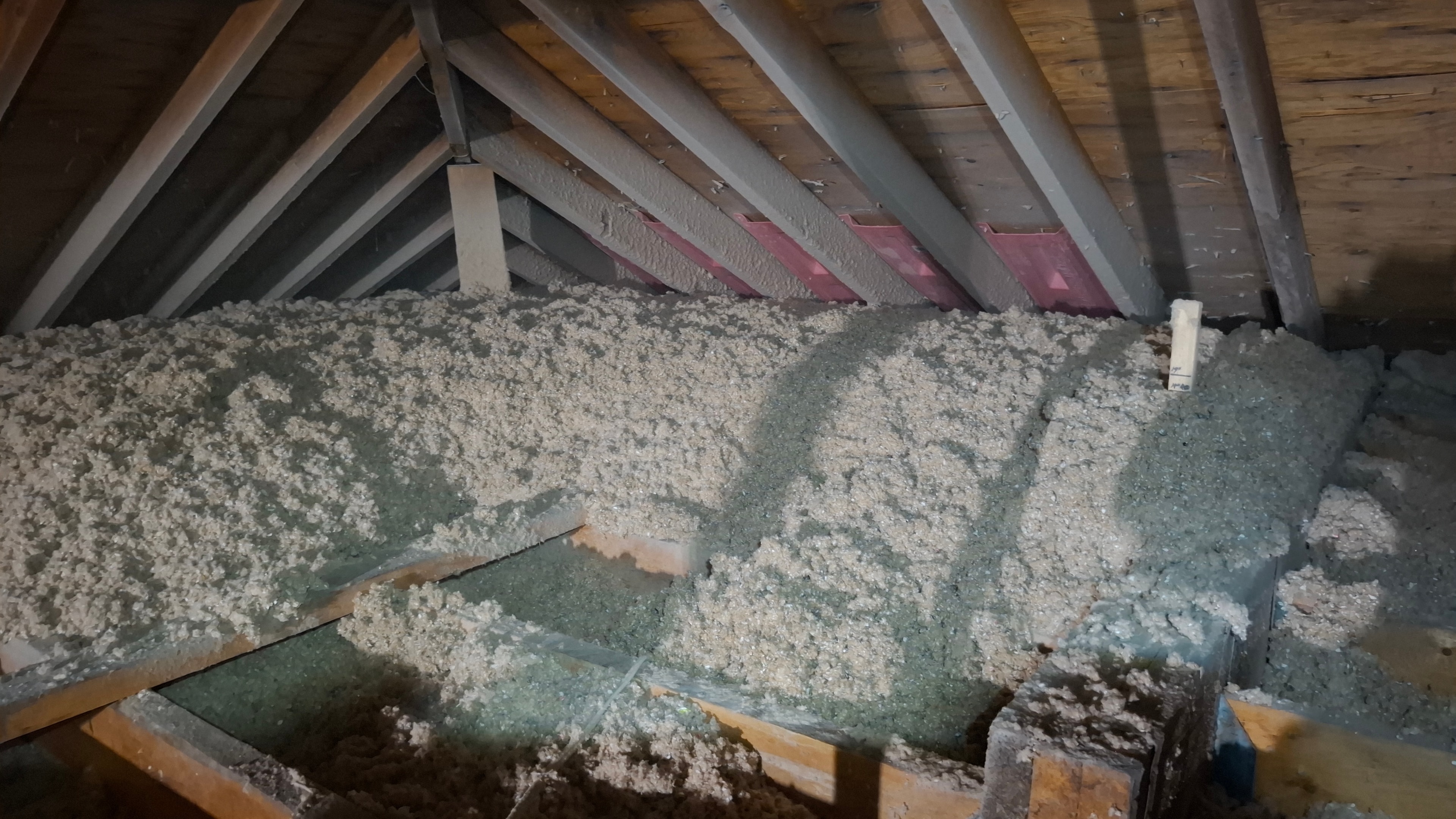 Completed blown-in cellulose attic insulation at Osgoode residential property — wide view showing full coverage with pink ventilation baffles visible at eaves