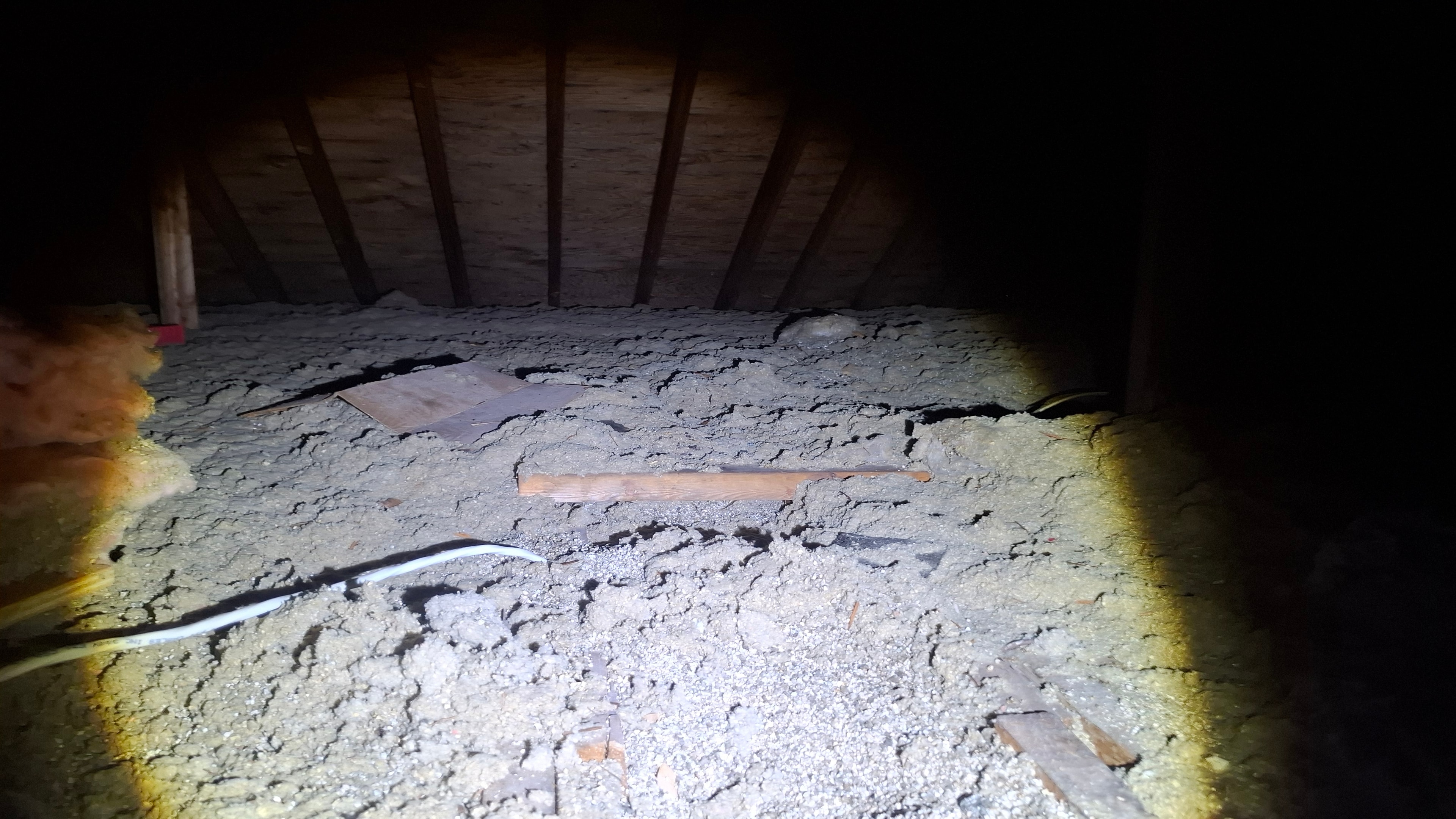 Before abatement — vermiculite insulation visible on attic ceiling boards between joists, Osgoode Ontario residential property