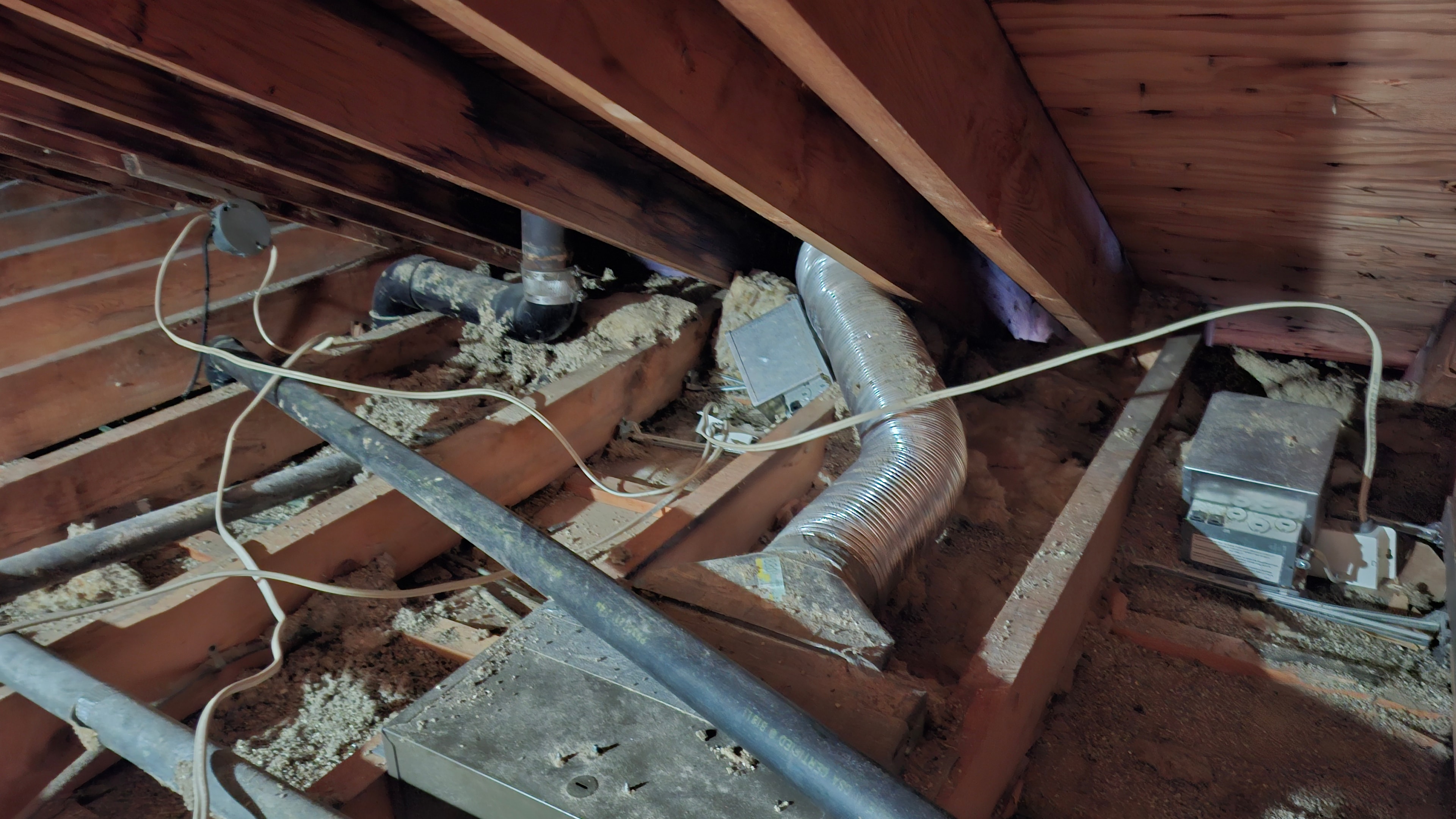 Before abatement — attic interior showing ductwork, wiring, and minimal existing insulation between joists, Osgoode Ontario
