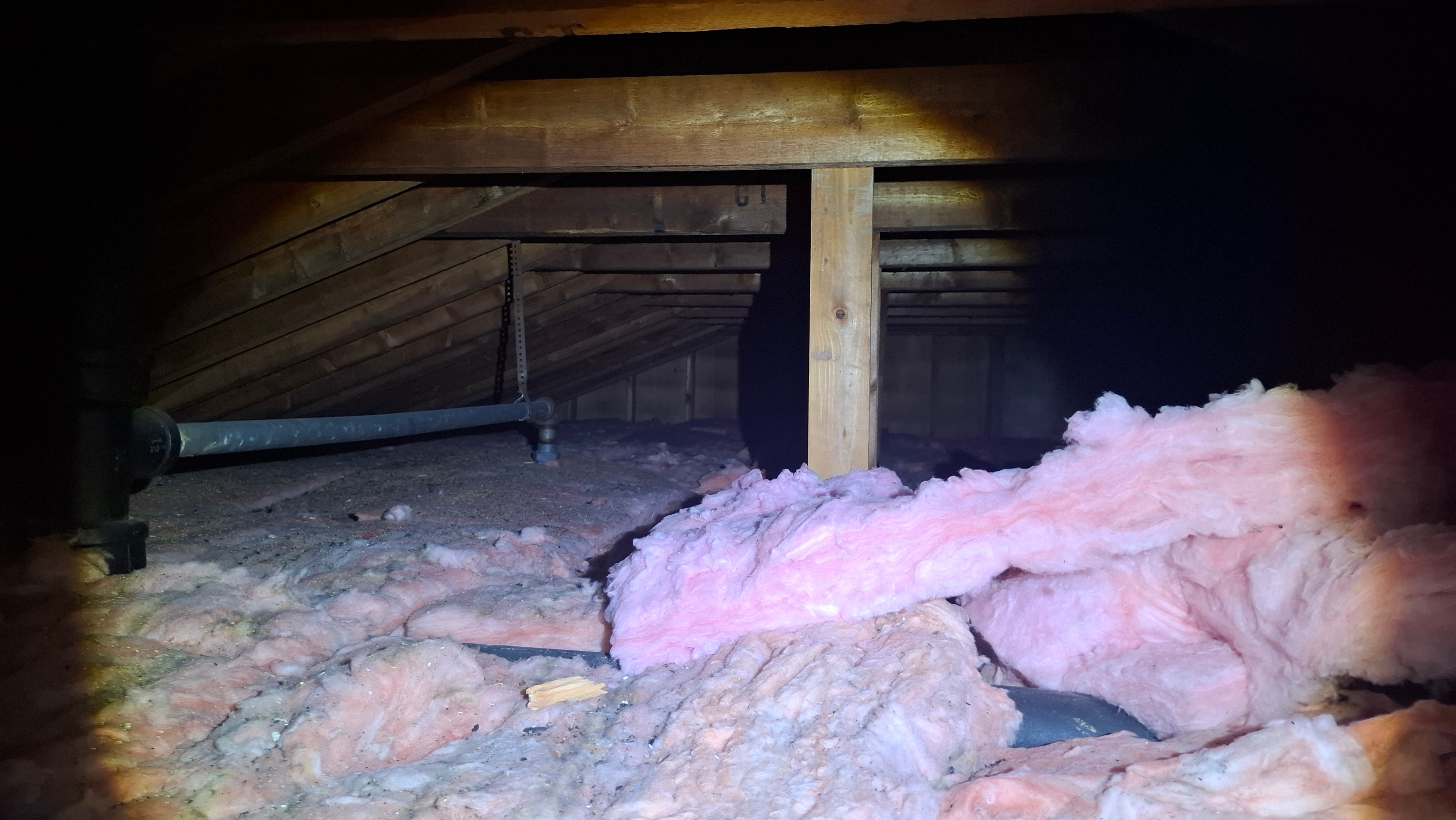 Attic framing with fiberglass insulation and vermiculite ACM between joists