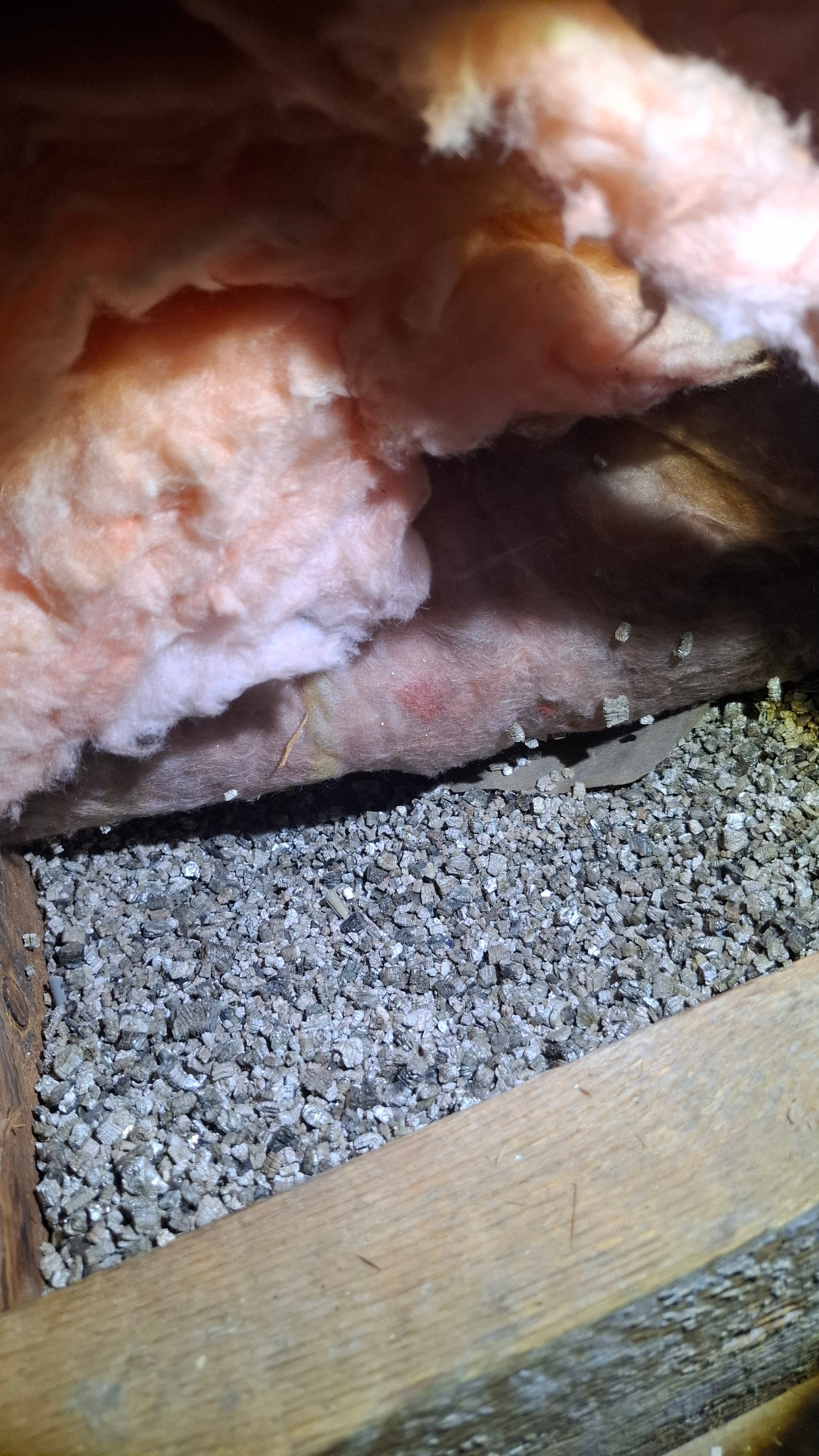 Close-up of vermiculite insulation granules alongside fiberglass batt material