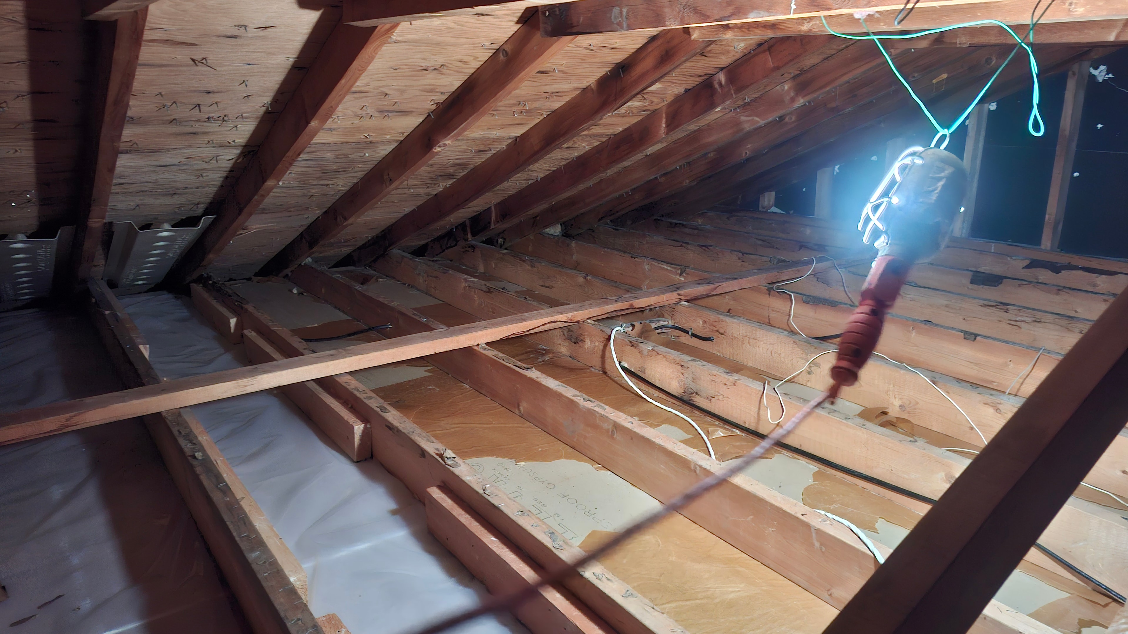 Attic fully cleared after Type 3 vermiculite abatement — clean joists and vapour barrier visible