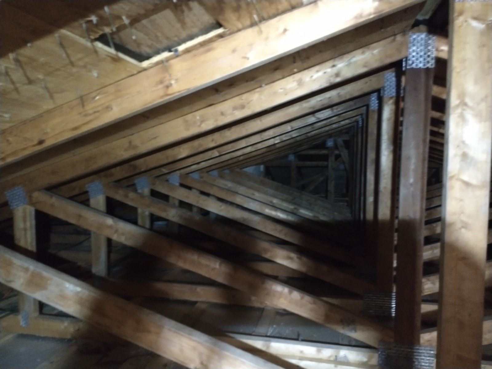 Attic truss structure after vermiculite abatement showing clean framing