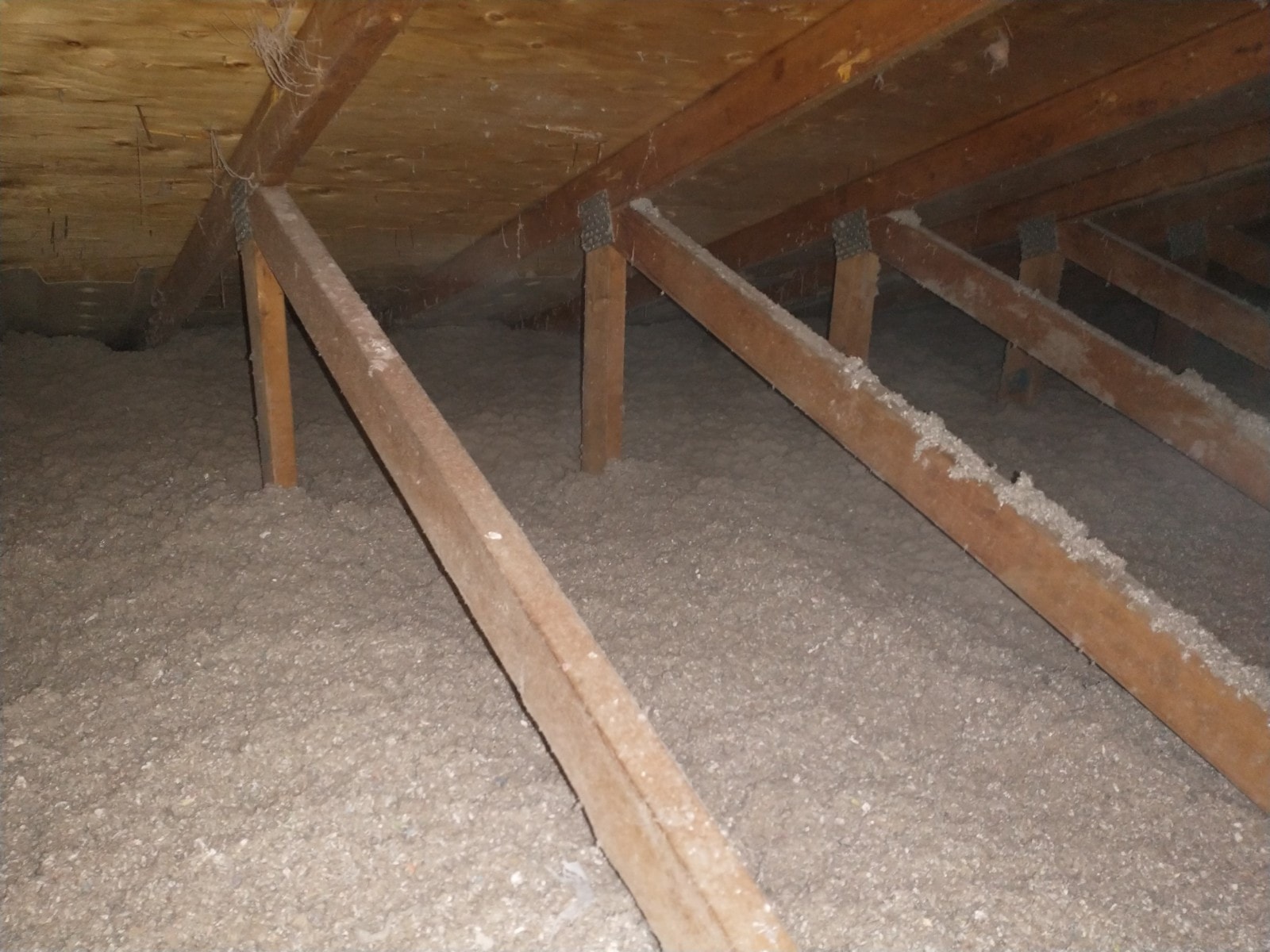 Blown-in cellulose insulation installed across attic floor after vermiculite abatement